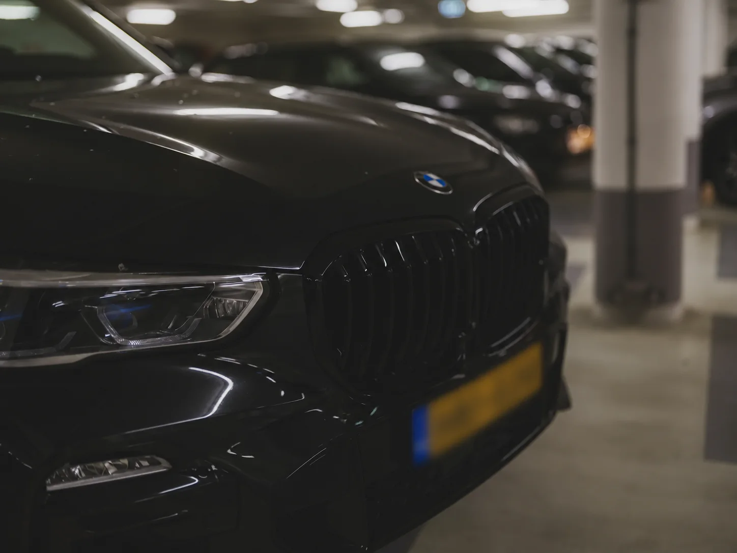 Black BMW photographed in a modern parking garage